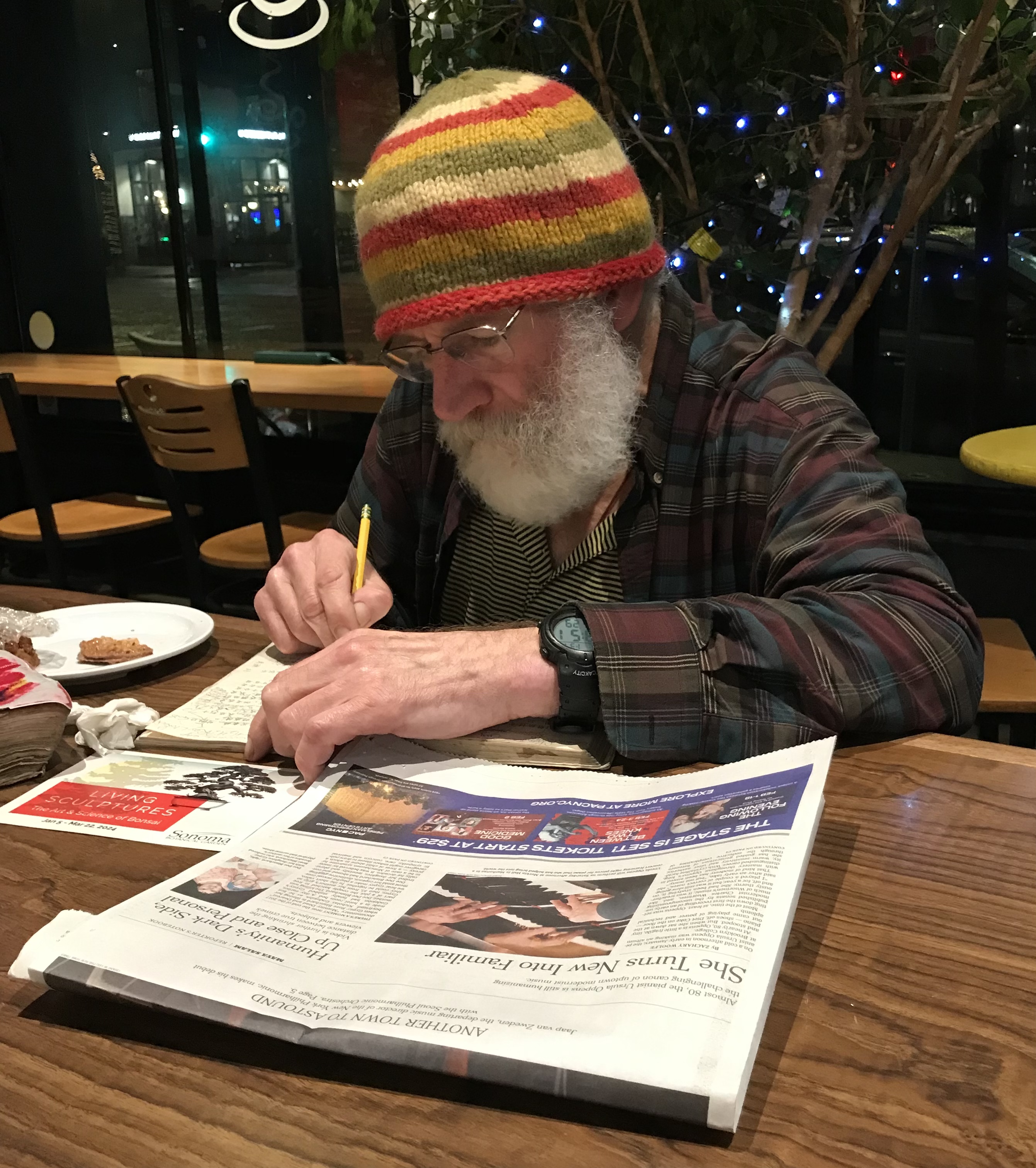 Eric writing notes at a cafe table
